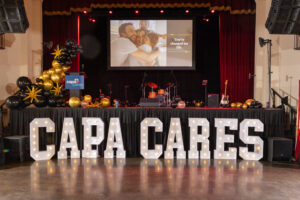 CAPACARES spelled in marquee letters in front of the stage